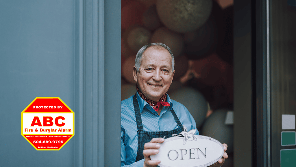 business owner holding open sign - Top Security Mistakes Businesses Make