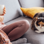 woman sitting down with her cat enjoying her smart home system